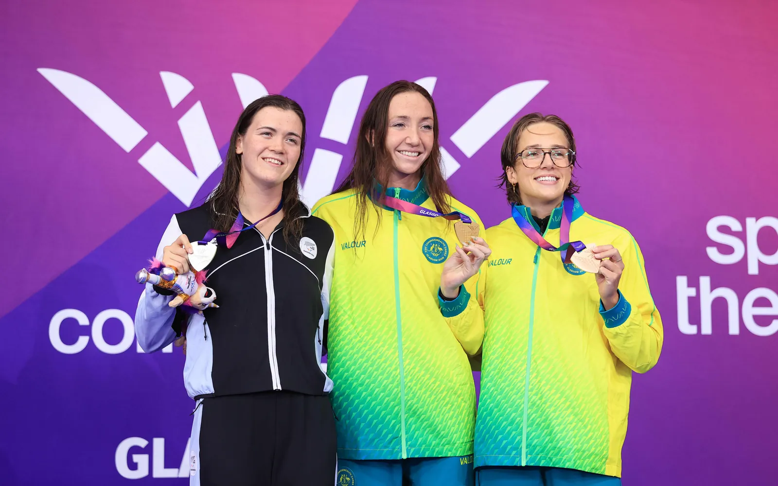 Erika Fairweather (L) celebrates her Commonwealth Games 400m freestyle silver medal with winner Lani Pallister (C) and fellow-Australian Jenna Forrester (R).