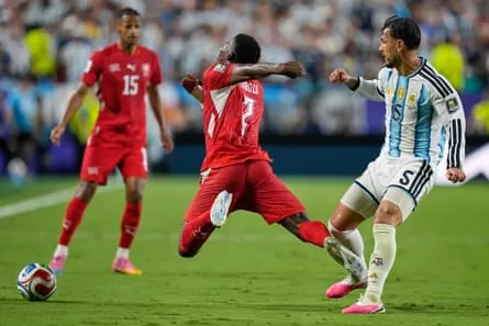 Switzerland’s Breel Embolo falls to ground under pressure from Argentina’s Leandro Paredes